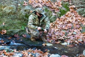 Στρατιώτης αντλεί νερό σε δάσος φθινοπώρου.