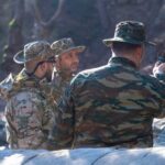 Στρατιωτικό προσωπικό σε συζήτηση στο δάσος.