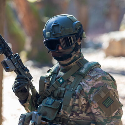 Στρατιώτης με στολή και όπλο στο δάσος.