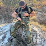 Στρατιωτικός εξοπλισμένος σε φυσικό τοπίο.