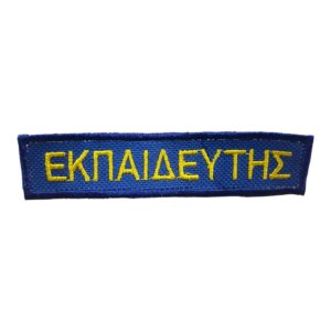 Μπλε υφασμάτινο έμβλημα με κίτρινη λέξη ΕΚΠΑΙΔΕΥΤΗΣ