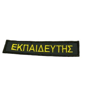 Μαύρο υφασμάτινο σήμα με κίτρινη λέξη ΕΚΠΑΙΔΕΥΤΗΣ